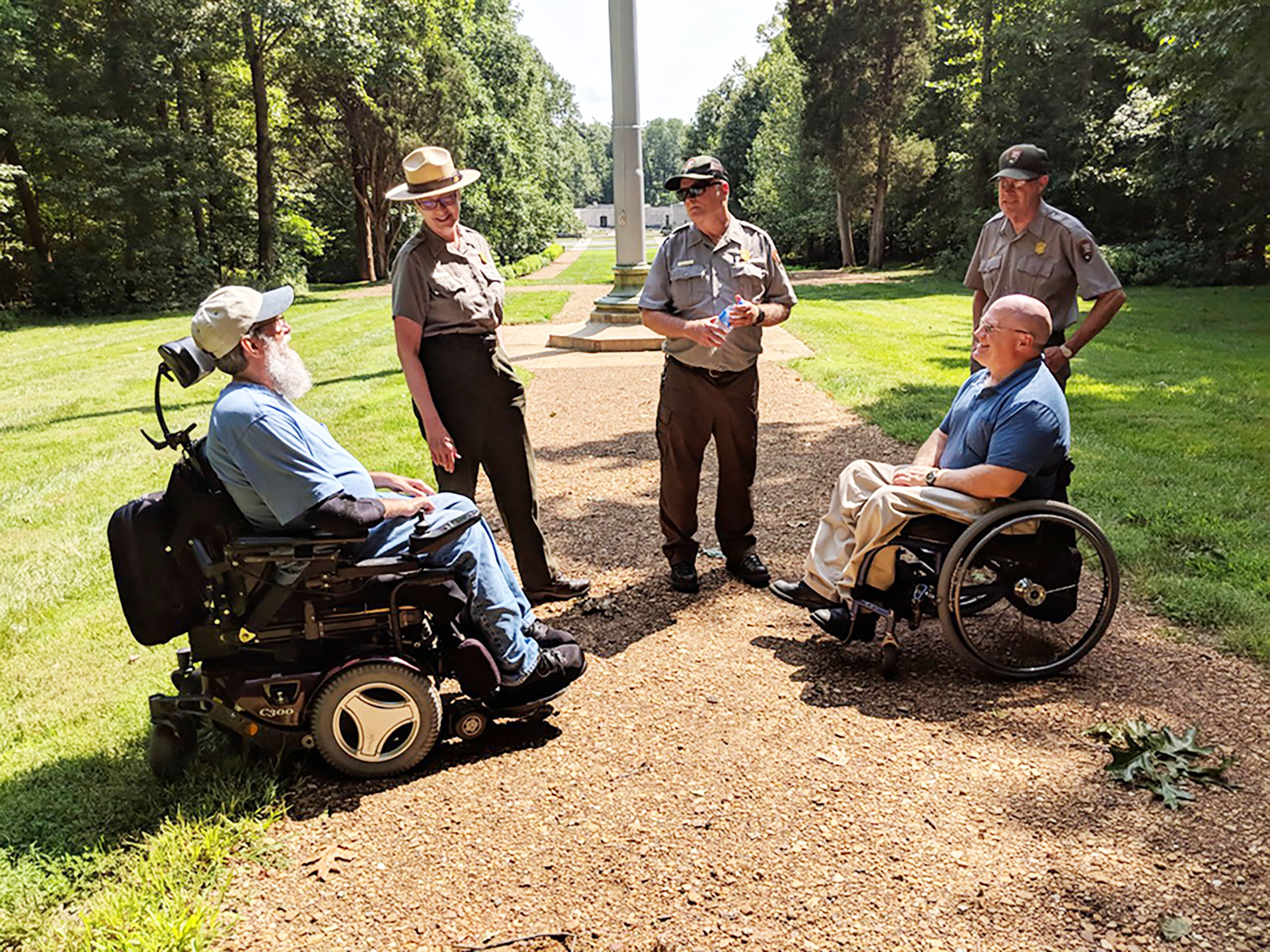 trail accessibility meeting Two men in wheelchairs meet with Park Rangers on park trail