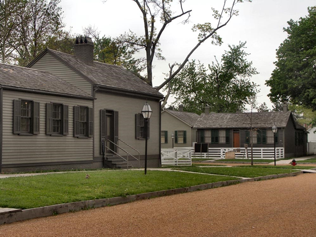 A small gray house on a corner intersection