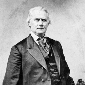 Photo of a middle-older aged man with white hair in a suit