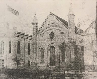 Temple church with thin arch entrances and two spires flanking main entrance face