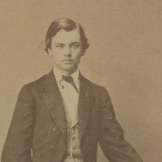 A black and white photo of a young boy with slick dark hair