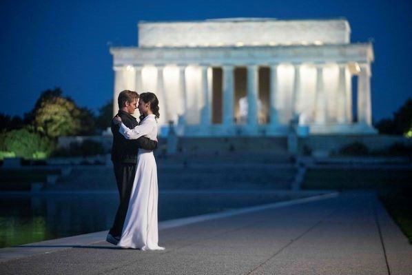 Two people dance along the Reflecting Pool with the Lincoln Memorial in the background