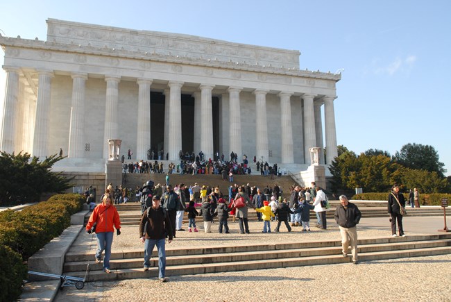 People walk up and down the steps leading to the Lincoln Memorial.