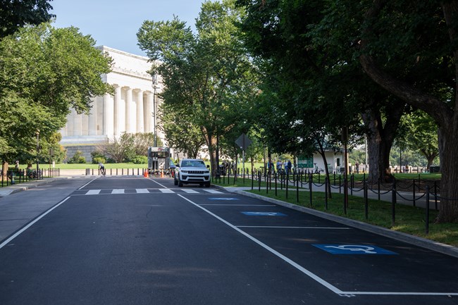 A line of accessible street parking spots along a street next to the Lincoln Memorial.