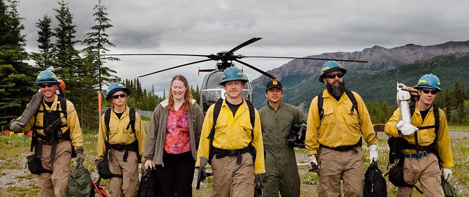 the western area fire crew walks in front of a helicopter