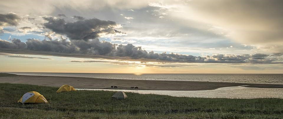 tents along a beach at sunset