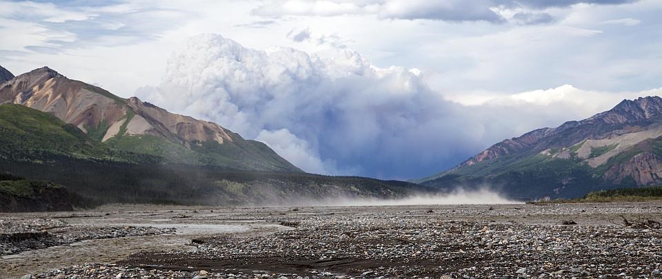 smoke rises behind mountains in the Sandless Fire in Denali NP