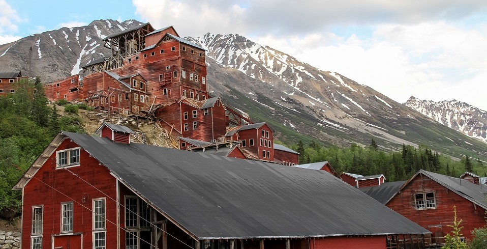 A red wooden building sits on a mountainside