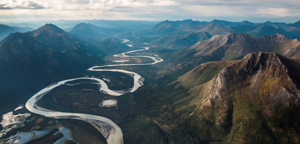 a river winds through mountains making many "S" curves