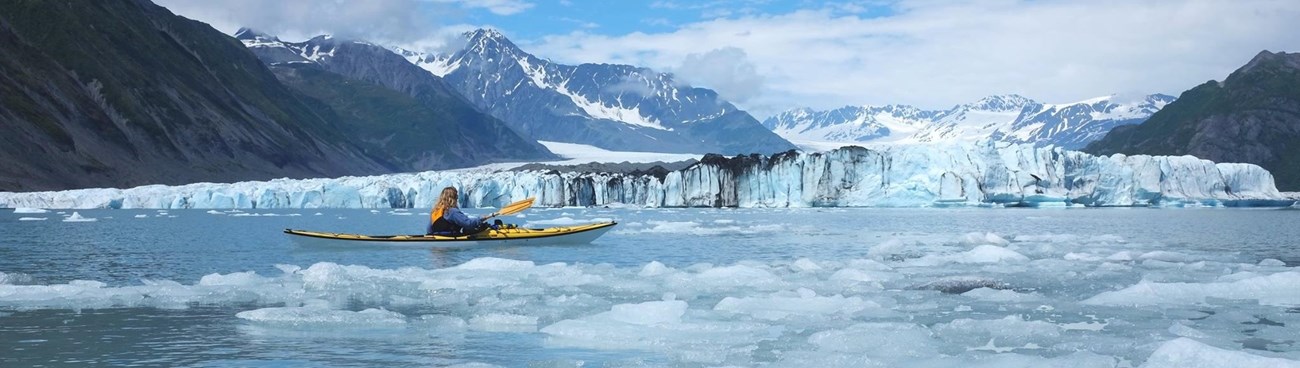 Woman kayaking through icy Alaskan waters