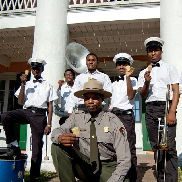 A National Park Service ranger with several Junior rangers