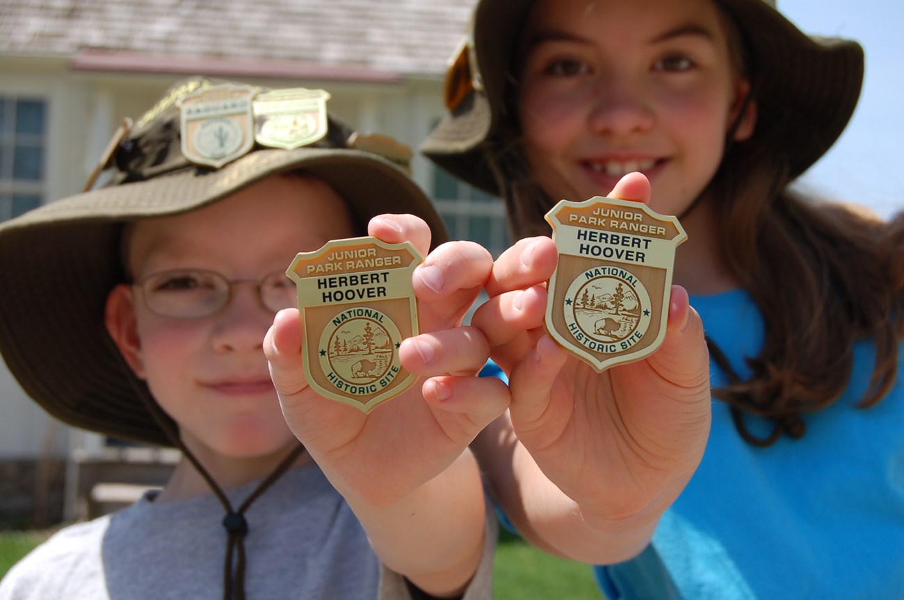 Junior Rangers A boy and girl show off their Junior Ranger hats and badges.