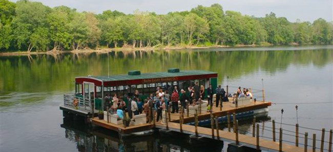 people on a river dock boarding a boat