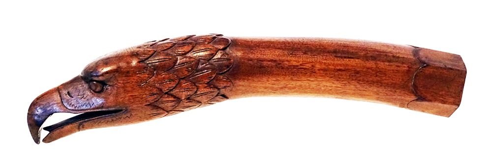 A wooden tiller handle carved in the shape of an eagle's head.
