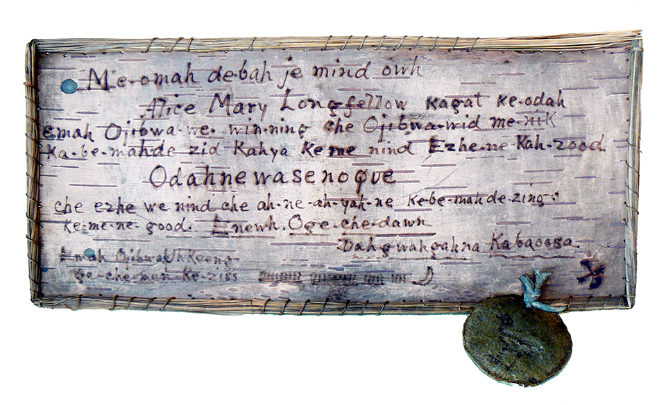 A birchbark certificate in Ojibwe given to Alice Longfellow, c. 1900. A birchbark certificate with text in Ojibwe written on it.