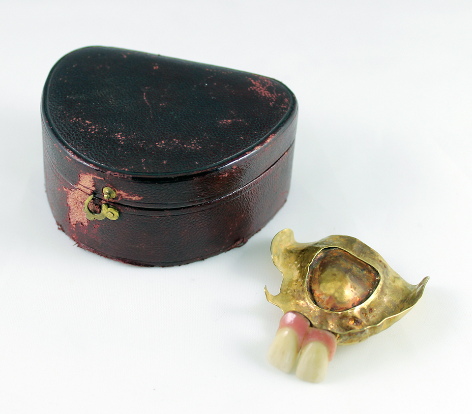A set of 19th century dentures with a gold plate and false teeth.