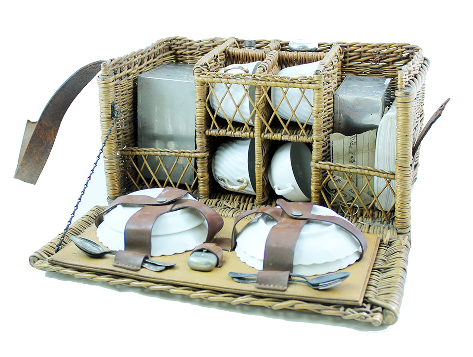 A wicker basket containing a portable tea set. A wicker basket containing a portable tea set.