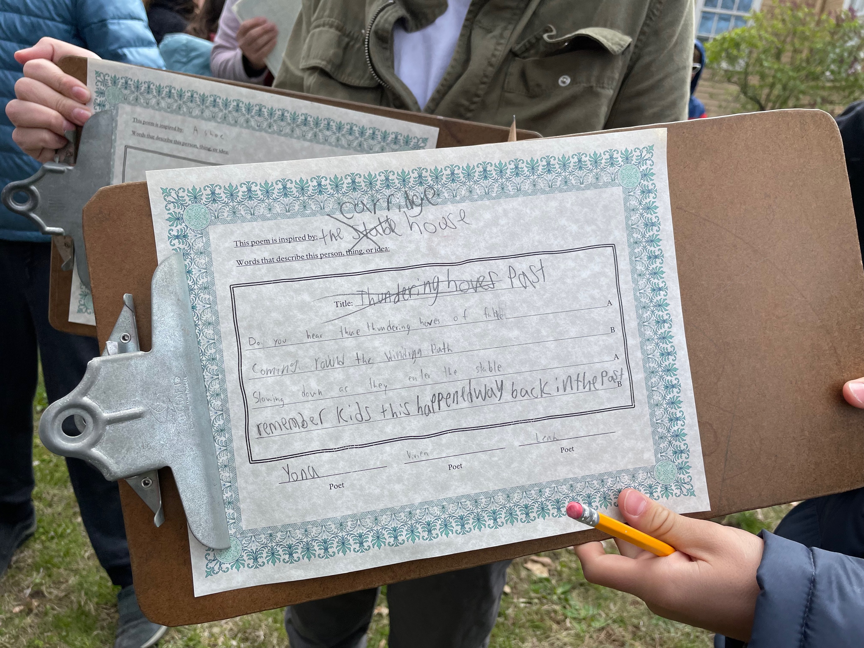 Close up of a handwritten poem held by a 5th grade student