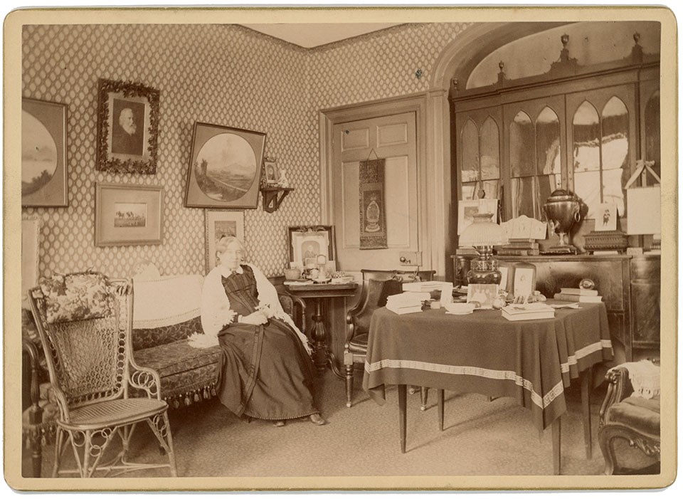 Woman sits on sofa in interior of home