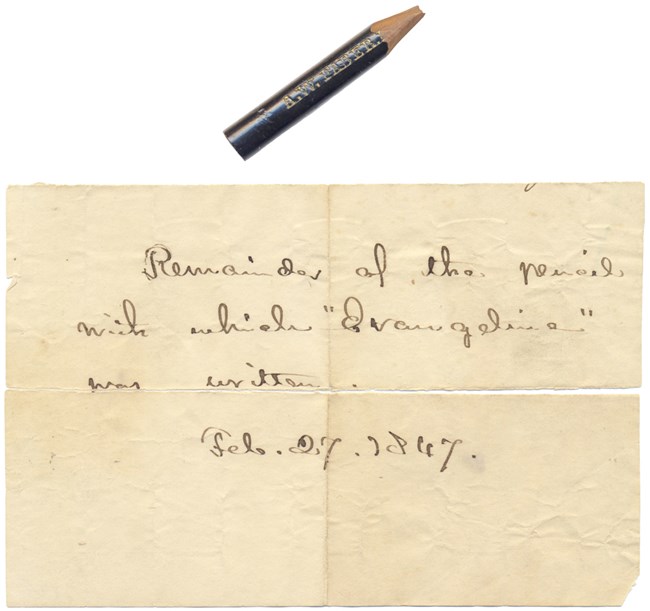 Small stub of a black pencil lays next to a handwritten manuscript that reads: “Remainder of the pencil with which ‘Evangeline’ was written. Feb. 27, 1847.”