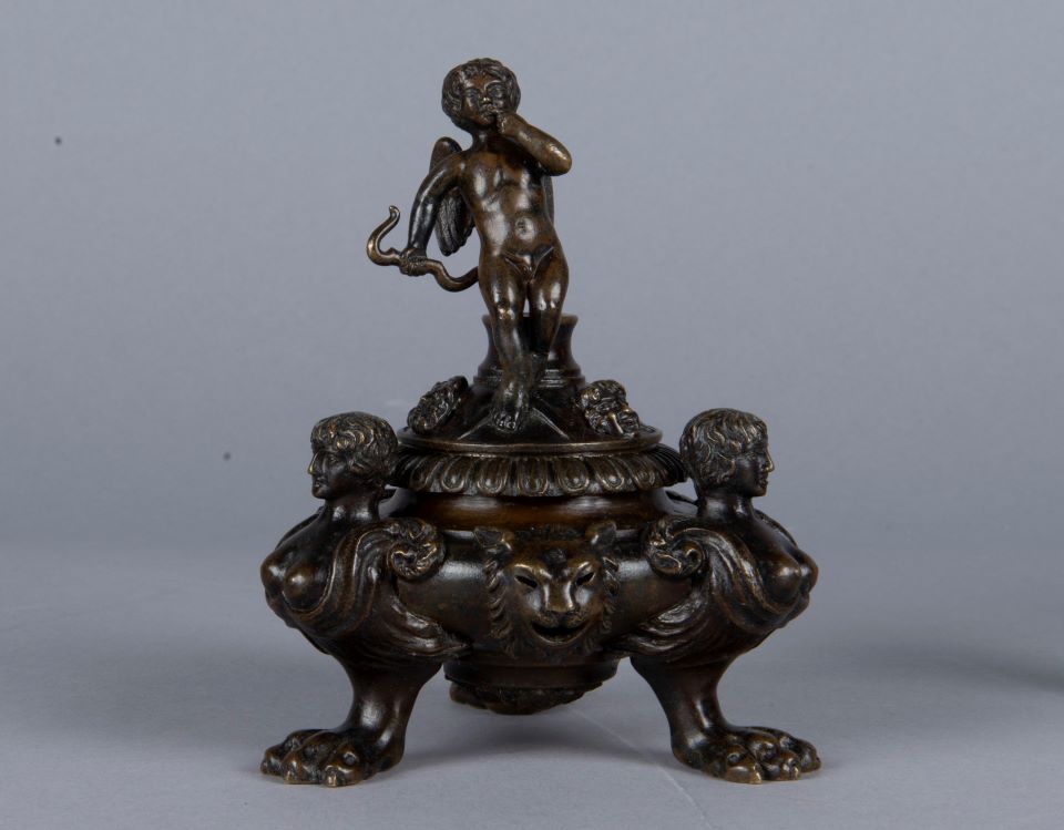 After conservation treatment Bronze inkstand with human figures at three corners, lion face on base, and standing cupid holding bow on top