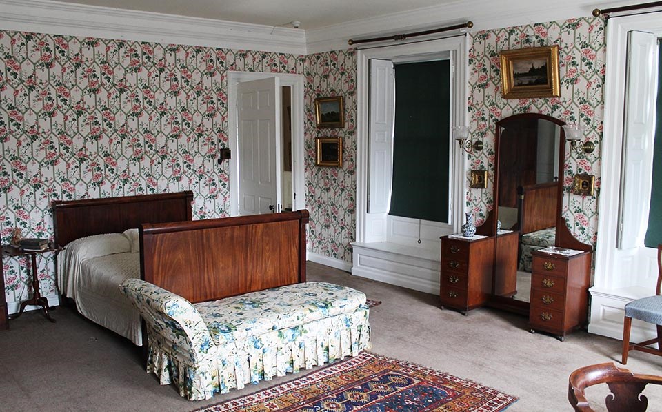 Interior of bedroom with sleigh bed and chaise at center