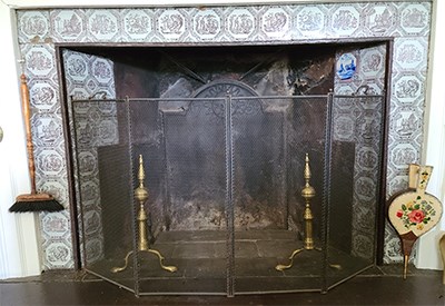 Fireplace with historic blue and white tiles surrounding.