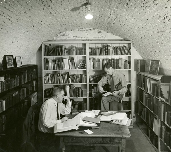 Two men surrounded by books in the basement archives, circa 1935 Two men surrounded by books in the basement archives, circa 1935