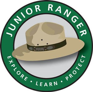 Junior Ranger Logo Logo with ranger hat in green circle and motto "Explore Learn Protect"