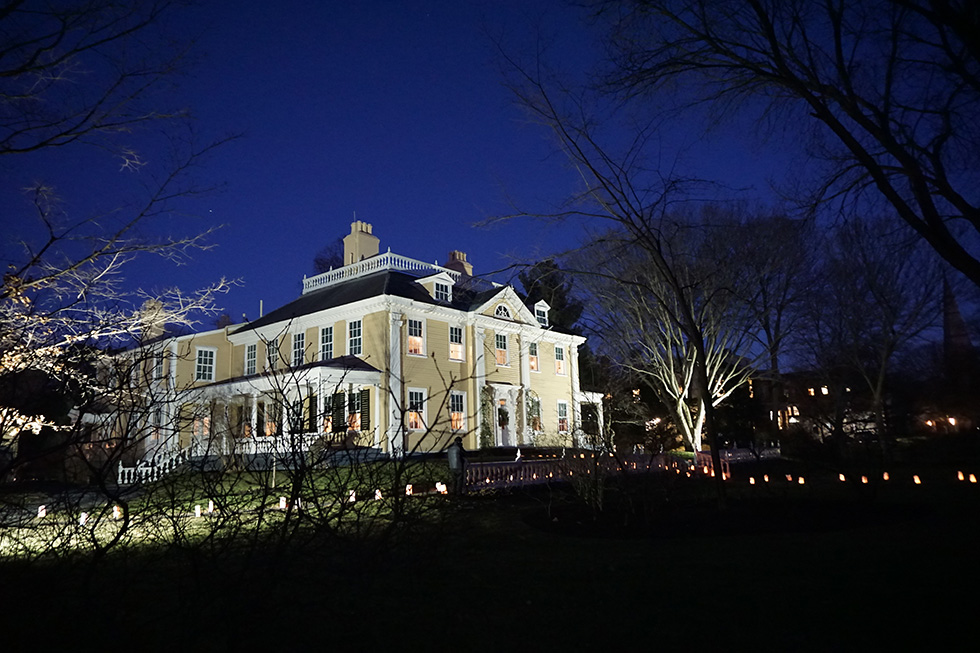 large house at night with luminaria lighting paths