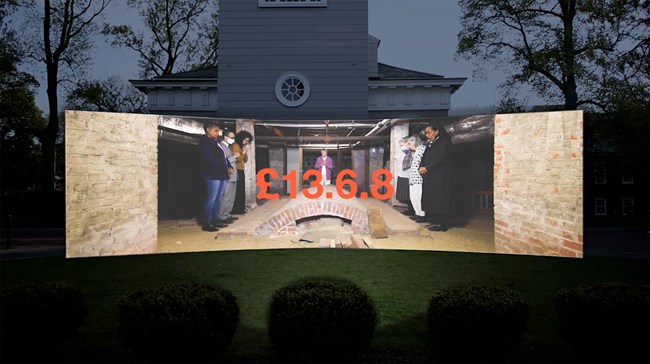 Mockup of outdoor video screen showing people gathered around a tomb and the text "£ 13.6.8"