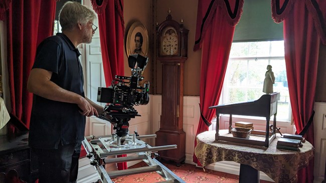 Man using a professional film camera in Henry Longellow's historic study