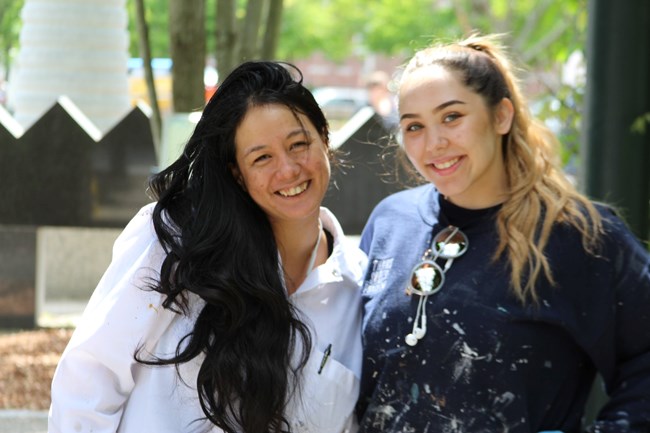 Two female painters pose for a picture.