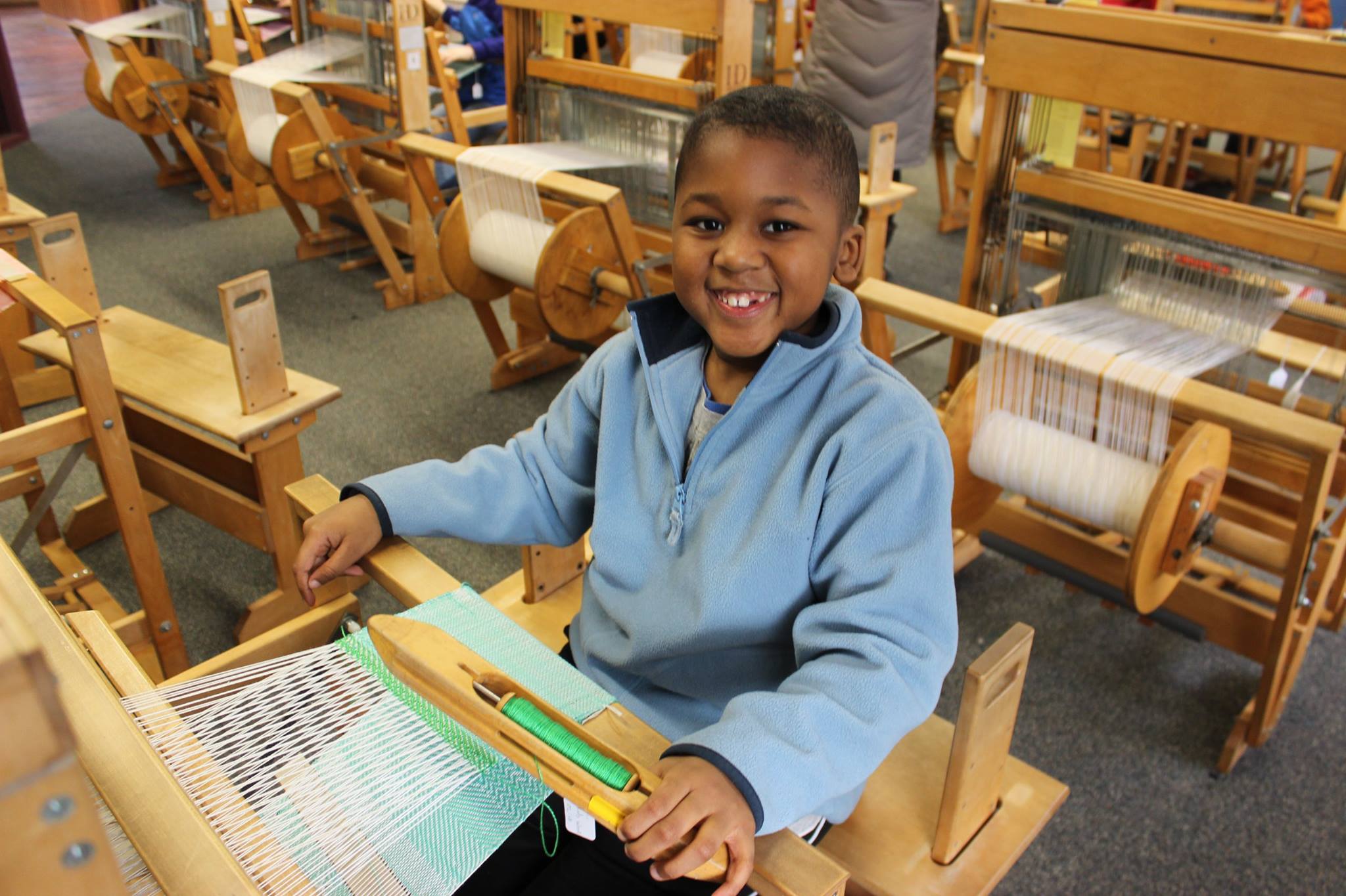 Weaving at the Tsongas Industrial History Center A boy weaving at the Tsongas Industrial History Center