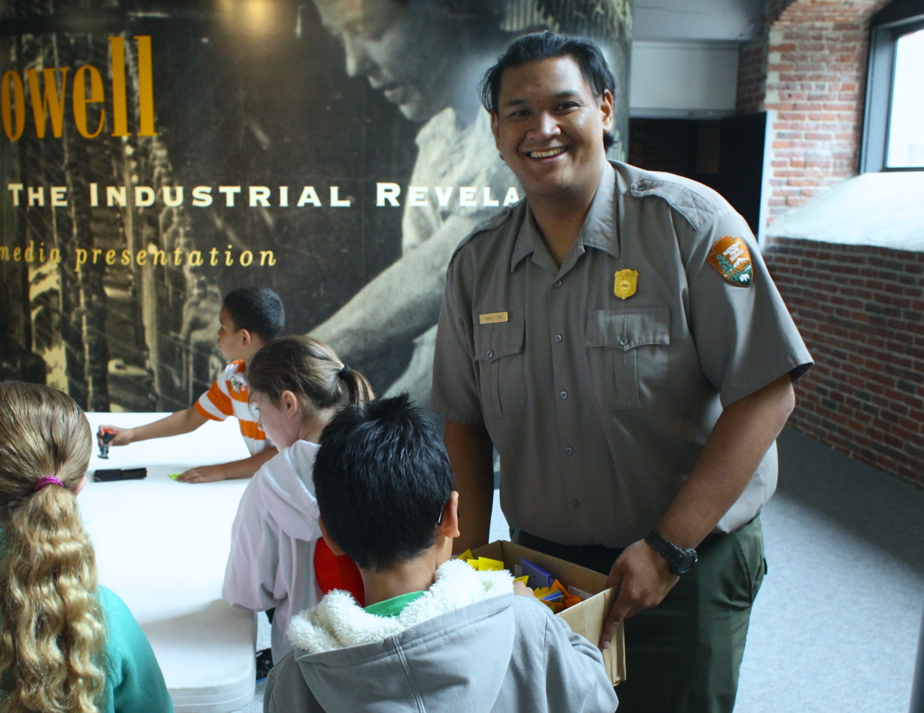 A Park Ranger helps kids with a craft A Park Ranger helps kids with a craft