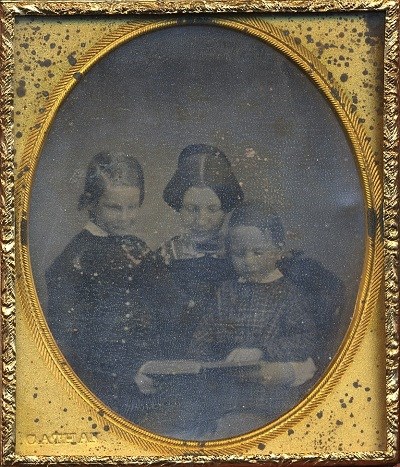 A woman (Fanny Appleton) reads a book to her two young sons