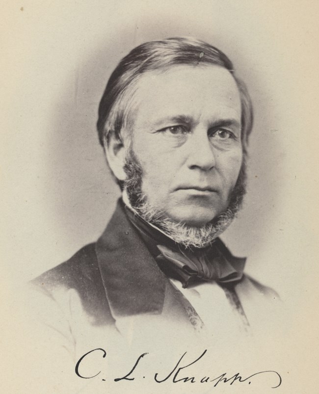 A photograph of Chauncey Langdon Knapp, a white man with a graying chinstrap beard that runs from his ears down under his chin without covering any part of his mouth or cheeks. Knapp is 39 in this image, and has faint wrinkles around his mouth and eyes