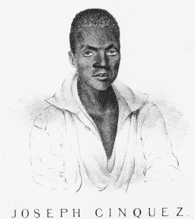 A drawing of a young black man in his mid twenties with short black hair. He is wearing a white collared shirt that is open to the mid chest. The text below the man reads, Joseph Cinquez, the brave Congolese Chief who prefers death to Slavery.