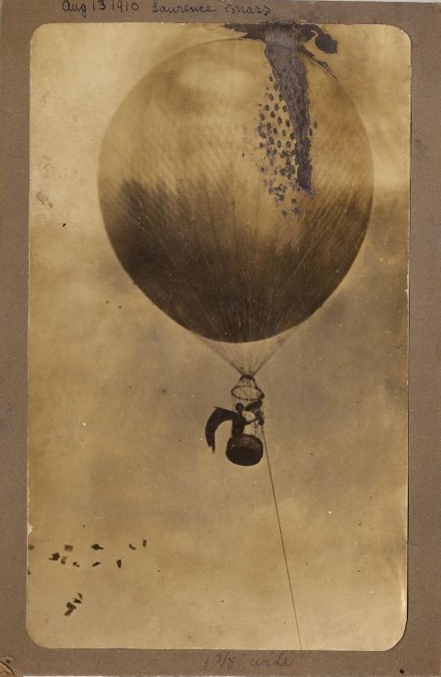 A sepia tone image of a hot air balloon floating in the sky with Margaret Foley in the basket