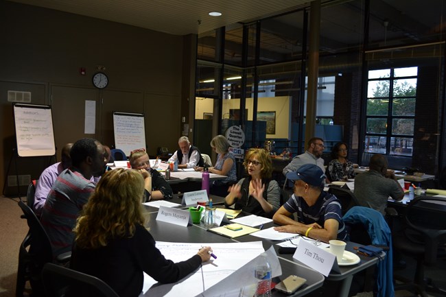 People sitting around a conference table discussing an exhibit
