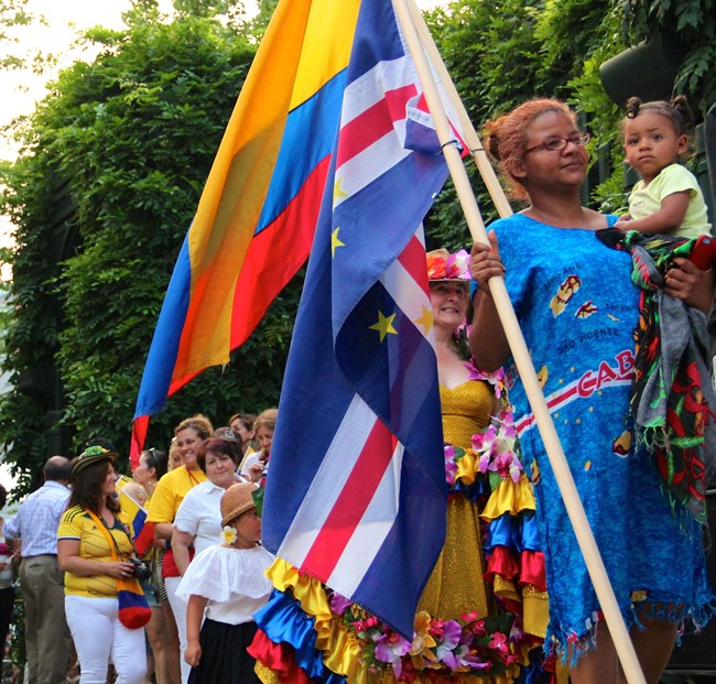 A woman holding a flag and a child walking in a parade