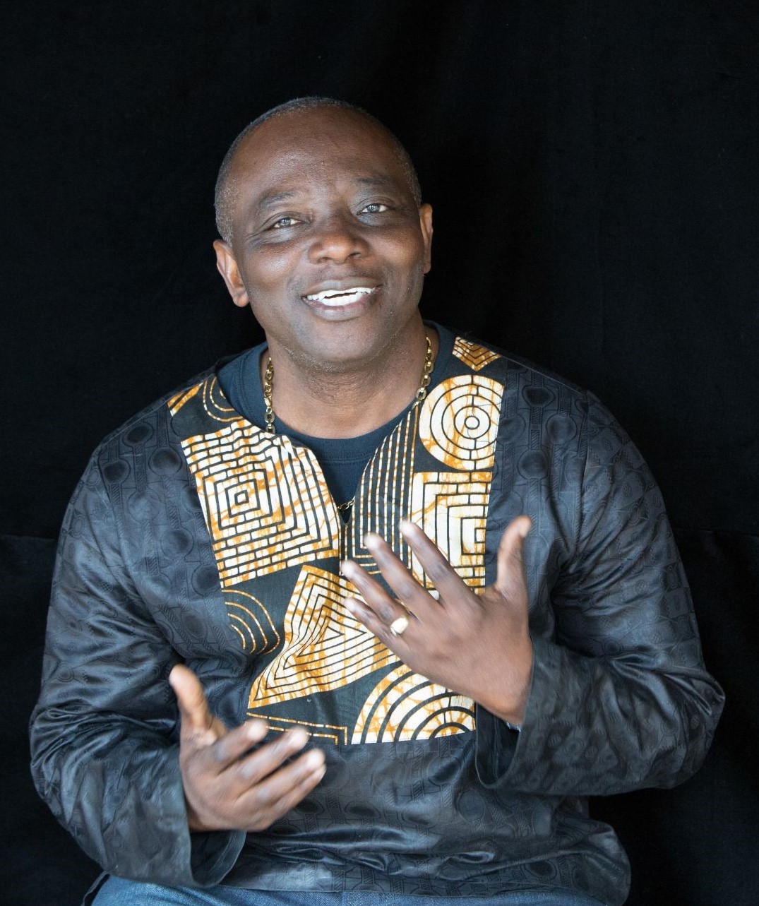 A man speaks in front of a black background
