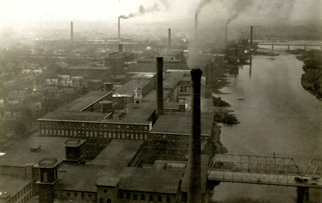 Rows of mills lined up along the Merrimack River spew black smog into the air