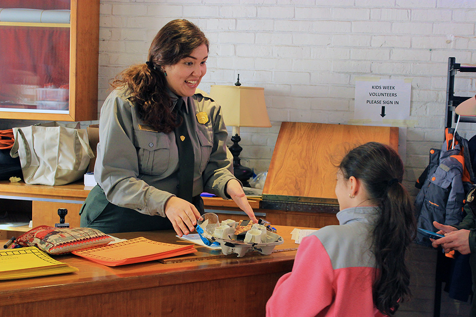 Ranger Bridget with guest park ranger talks to young visitor