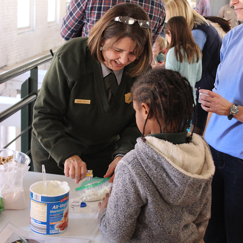 Ranger and young guest Park Ranger helps a young guest for Kids Week