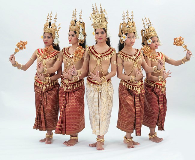A group of five female dancers from the Angkor Dance Troupe pose in traditional Cambodian costumes.