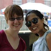 Two women wearing sunglasses and summer clothing pose for a picture