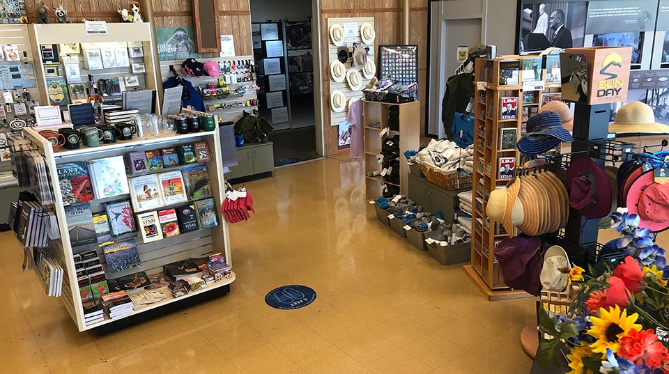 Shelves of books, postcards, hats, and t-shirts on display.