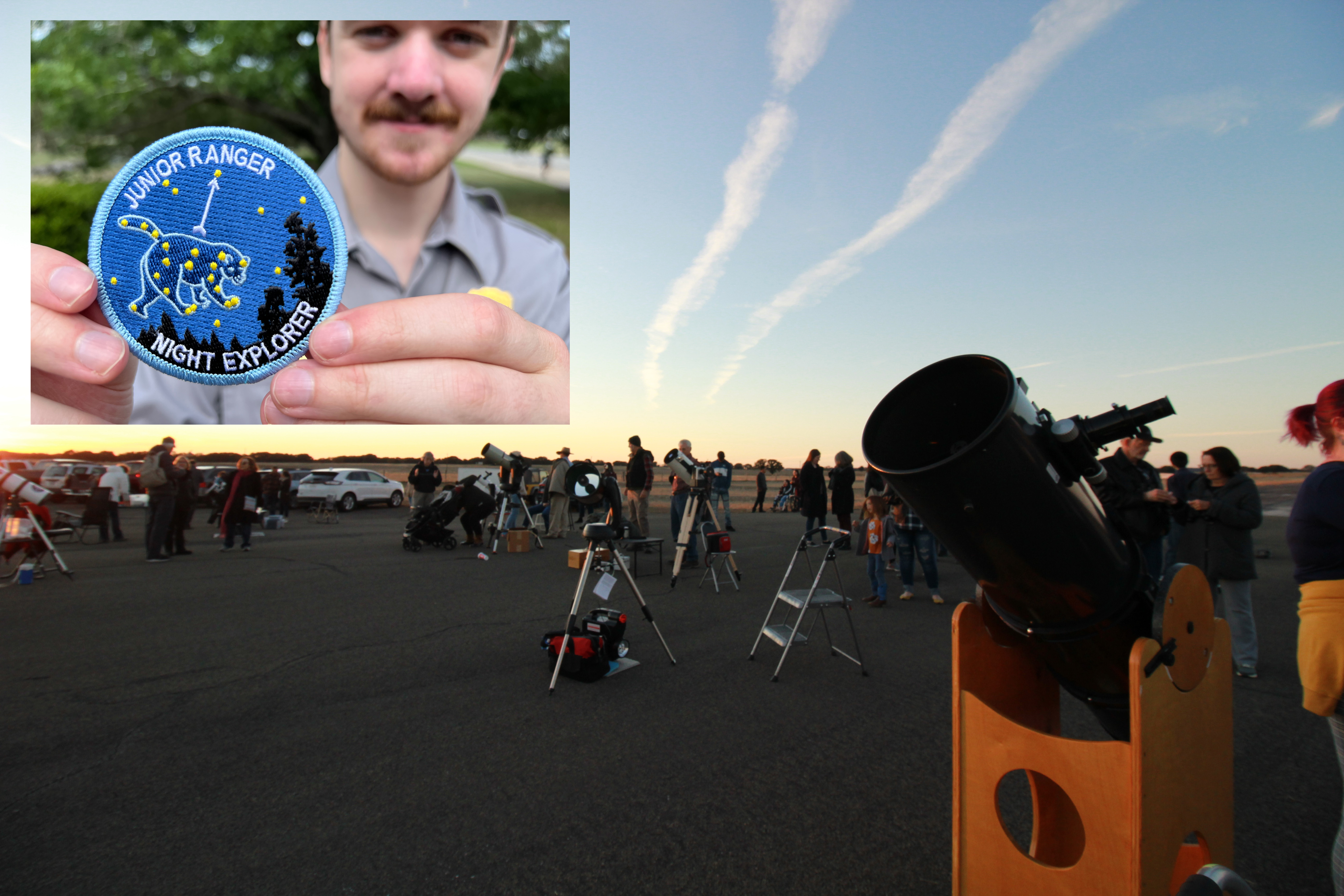 A crowd gathers around telescopes. Inset photo is a blue patch with stars and words that read "Junior Ranger Night Explorer."