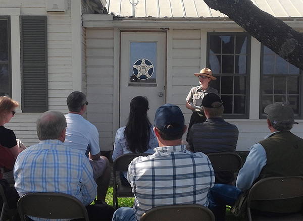 A park ranger talks to a group of visitors in front of the door to the Secret Service command post.